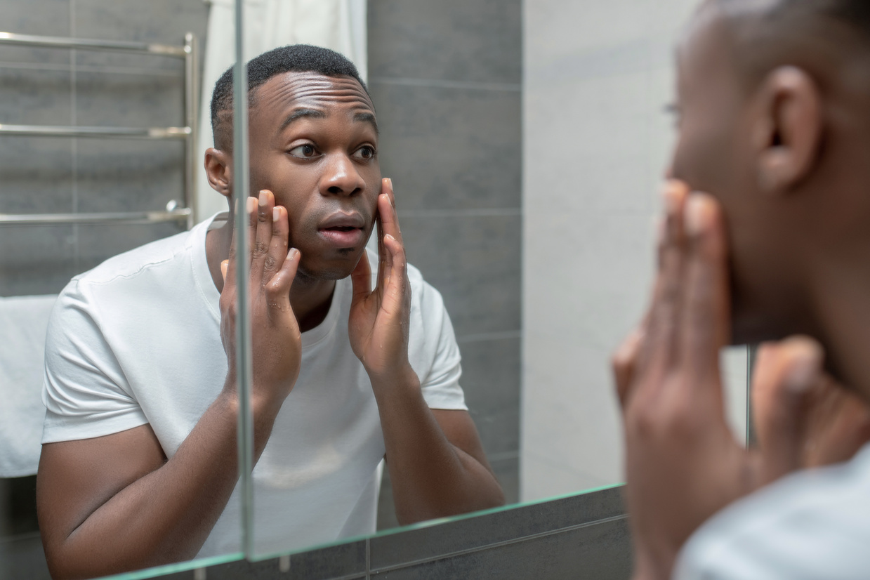 Dark-Skinned Man Does Morning Skin Care