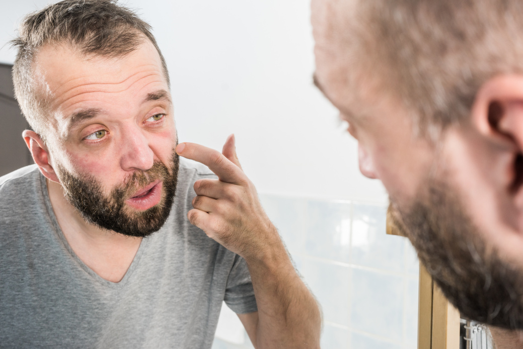 Man looking at wrinkles on his face