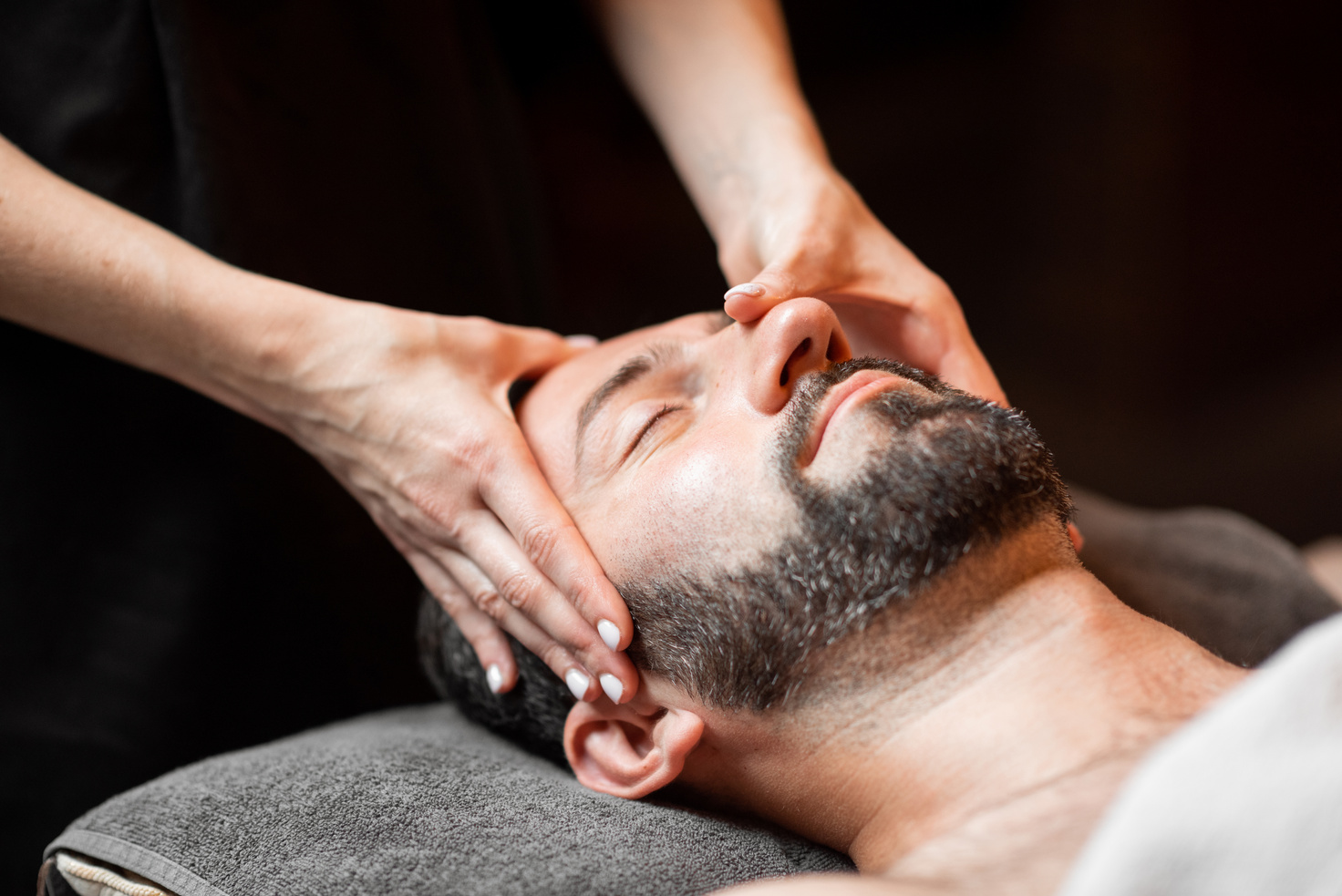 Man receiving facial massage at Spa salon